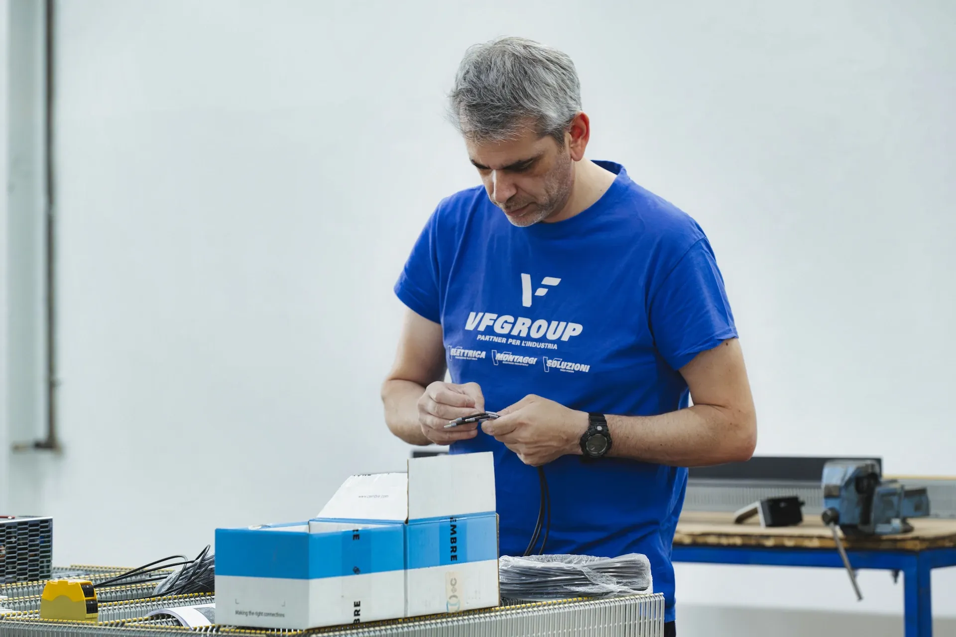 Tecnico VF Group prepara componenti elettrici al banco di lavoro